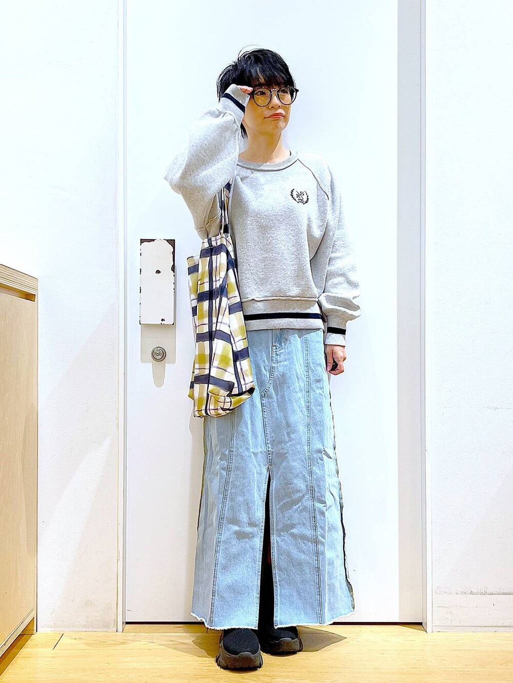 ブルー系のデニムスカート、その他のトートバッグ、ブラック系のブーツを着用したレディースの冬コーディネートの2枚目の写真