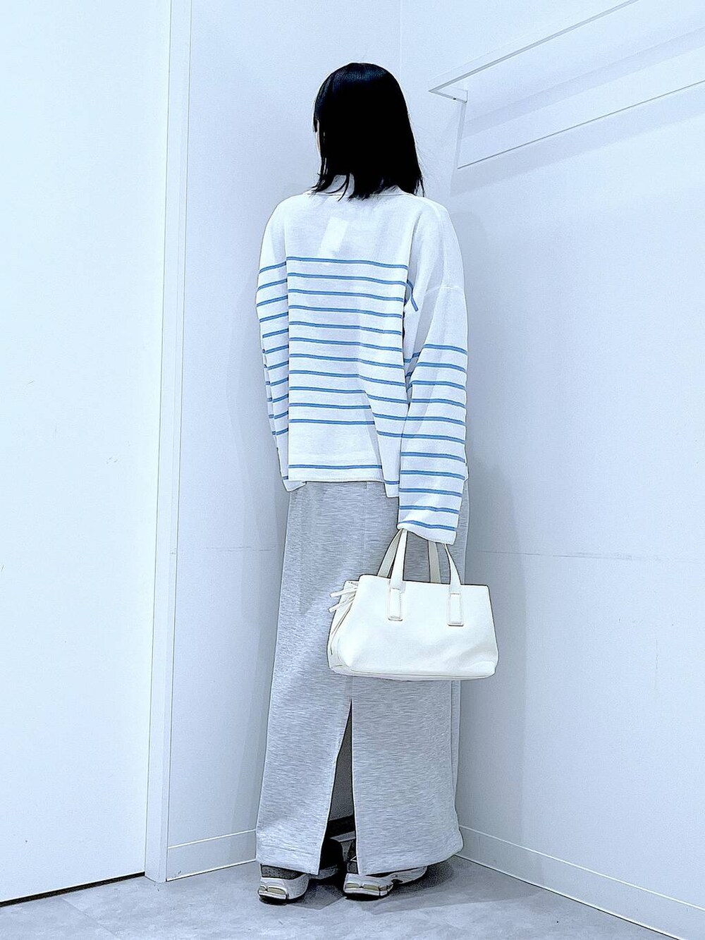 ホワイト系のボストンバッグ、グレー系のスカートを着用したレディースの春コーディネートの5枚目の写真