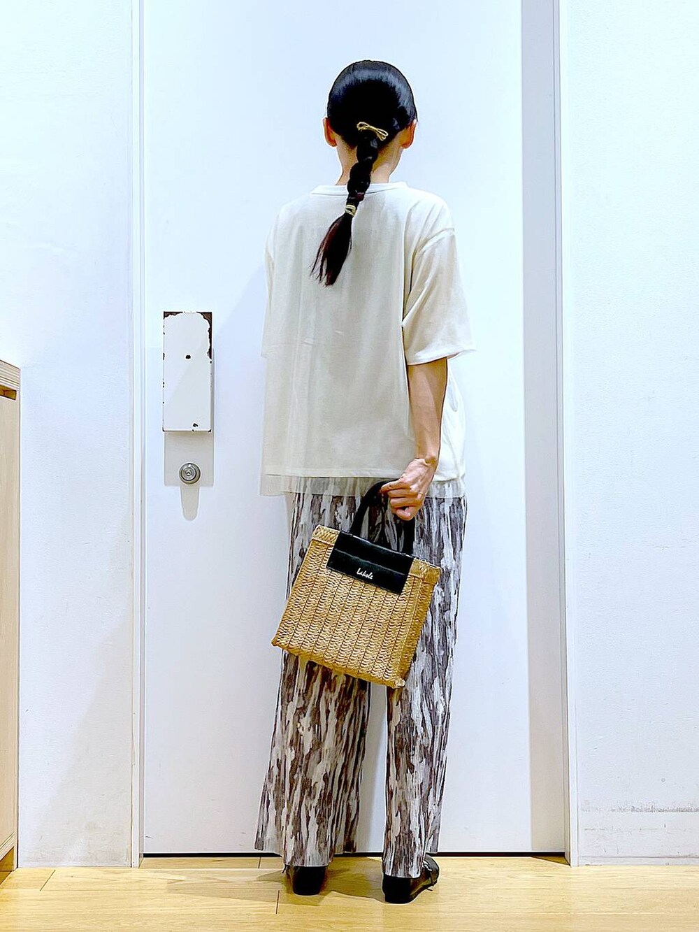 ホワイト系のTシャツ/カットソー、ブラック系のパンプス、ベージュ系のショルダーバッグを着用したレディースの夏コーディネートの5枚目の写真