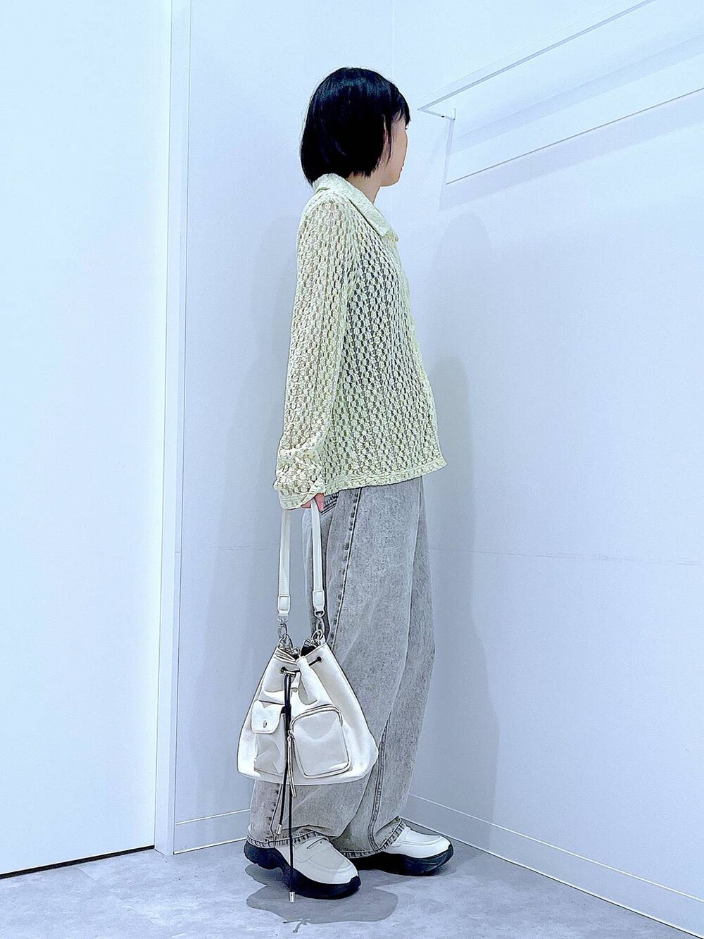 ベージュ系のデニムパンツ、ホワイト系のローファー、ホワイト系のショルダーバッグを着用したレディースの秋コーディネートの4枚目の写真