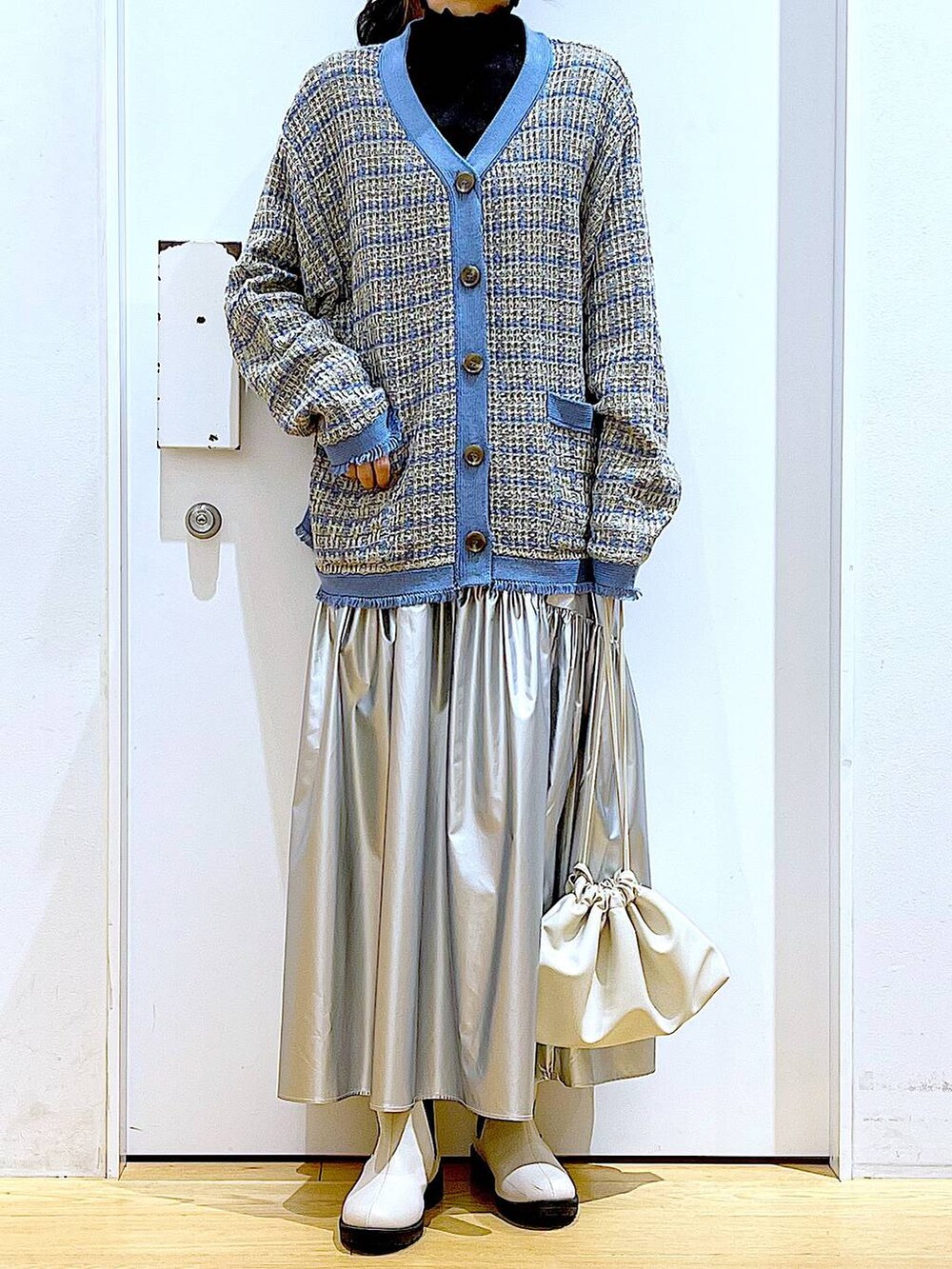 ブラック系のTシャツ/カットソー、シルバー系のスカート、ブルー系のカーディガン/ボレロを着用したレディースの冬コーディネートの6枚目の写真