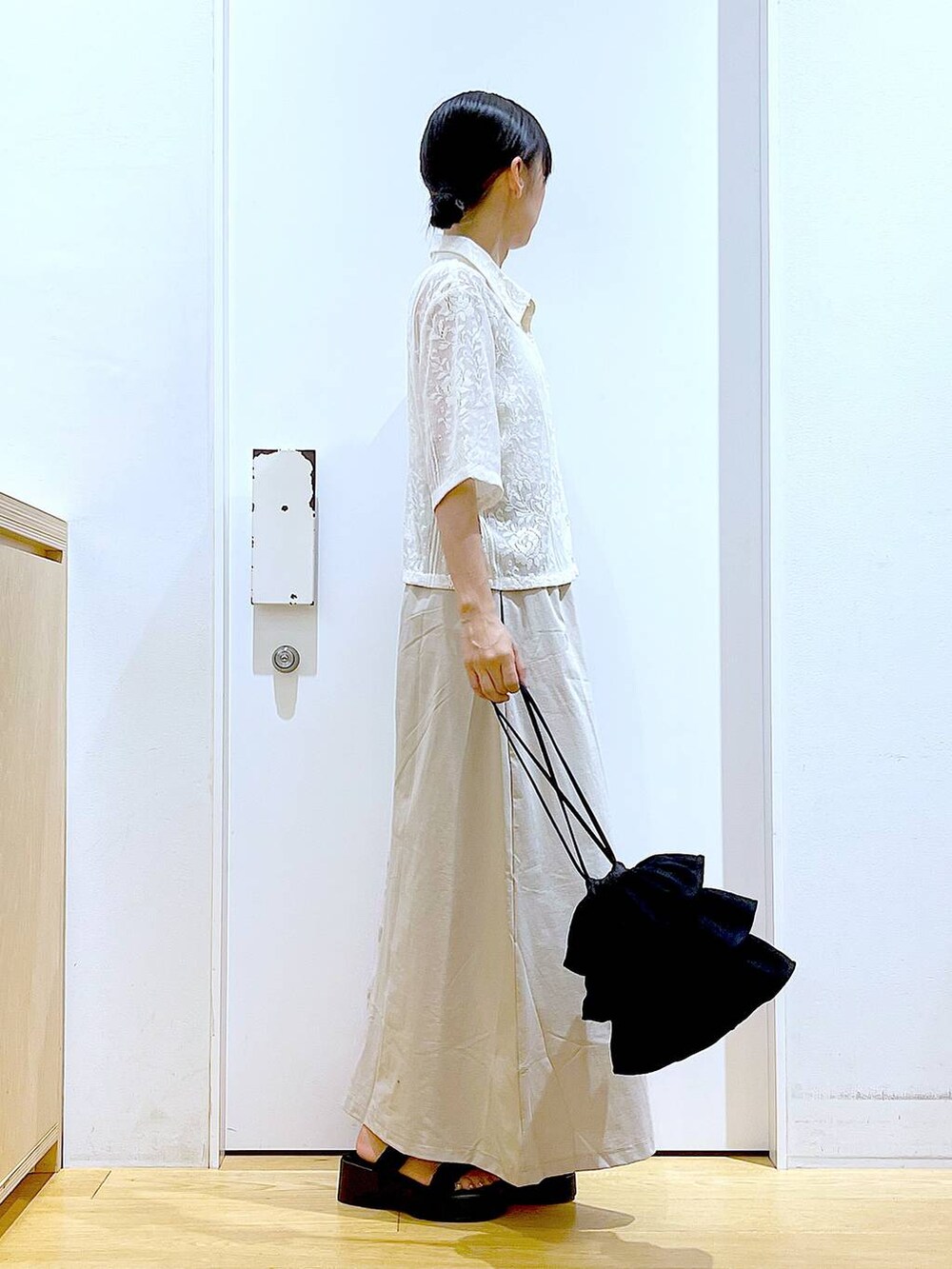 ブラック系のサンダル、ベージュ系のシャツ/ブラウス、ベージュ系のスカートを着用したレディースの夏コーディネートの4枚目の写真