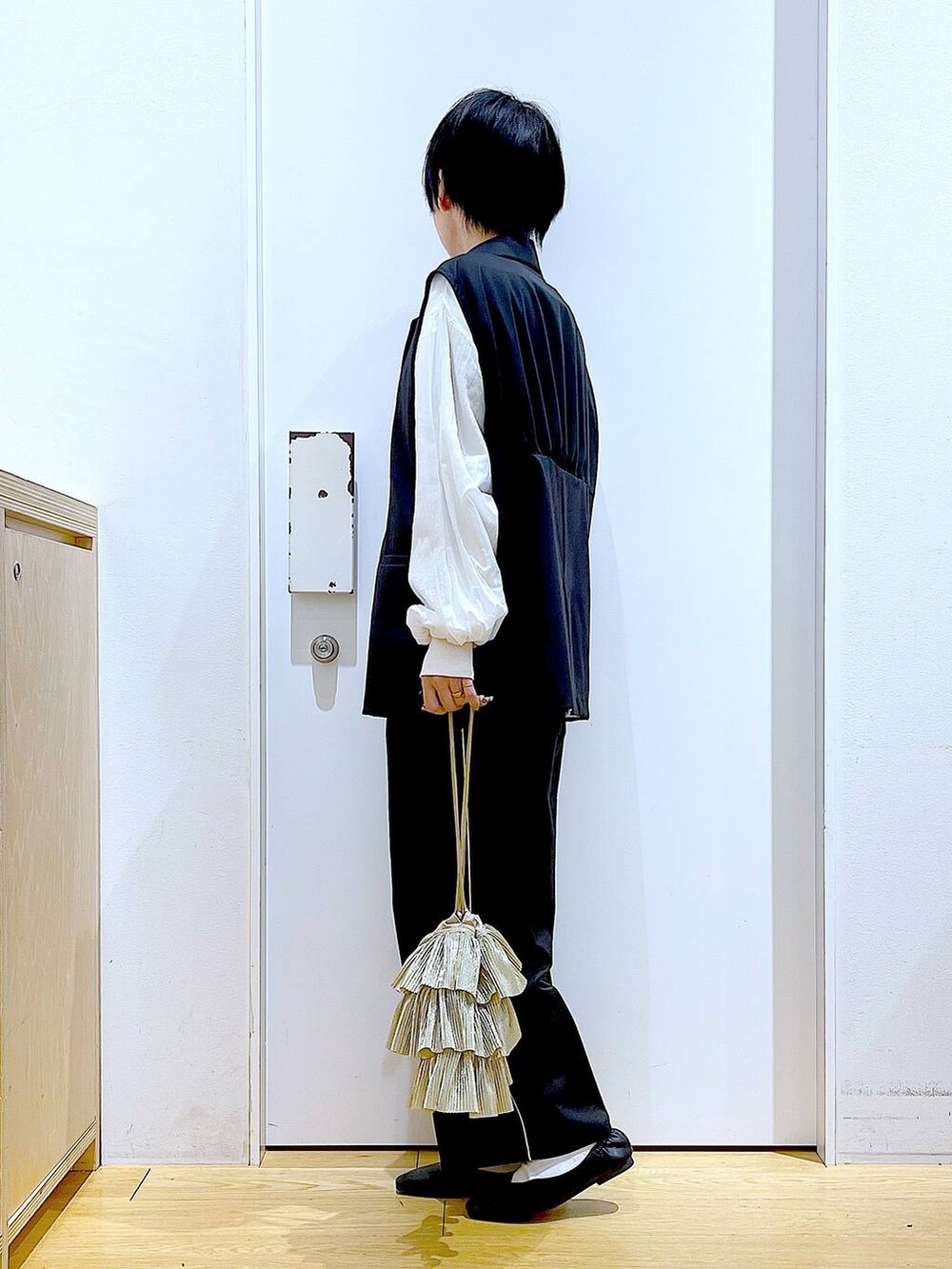 ブラック系のスラックス、ブラック系のパンプス、ホワイト系のスウェットを着用したレディースの春コーディネートの3枚目の写真