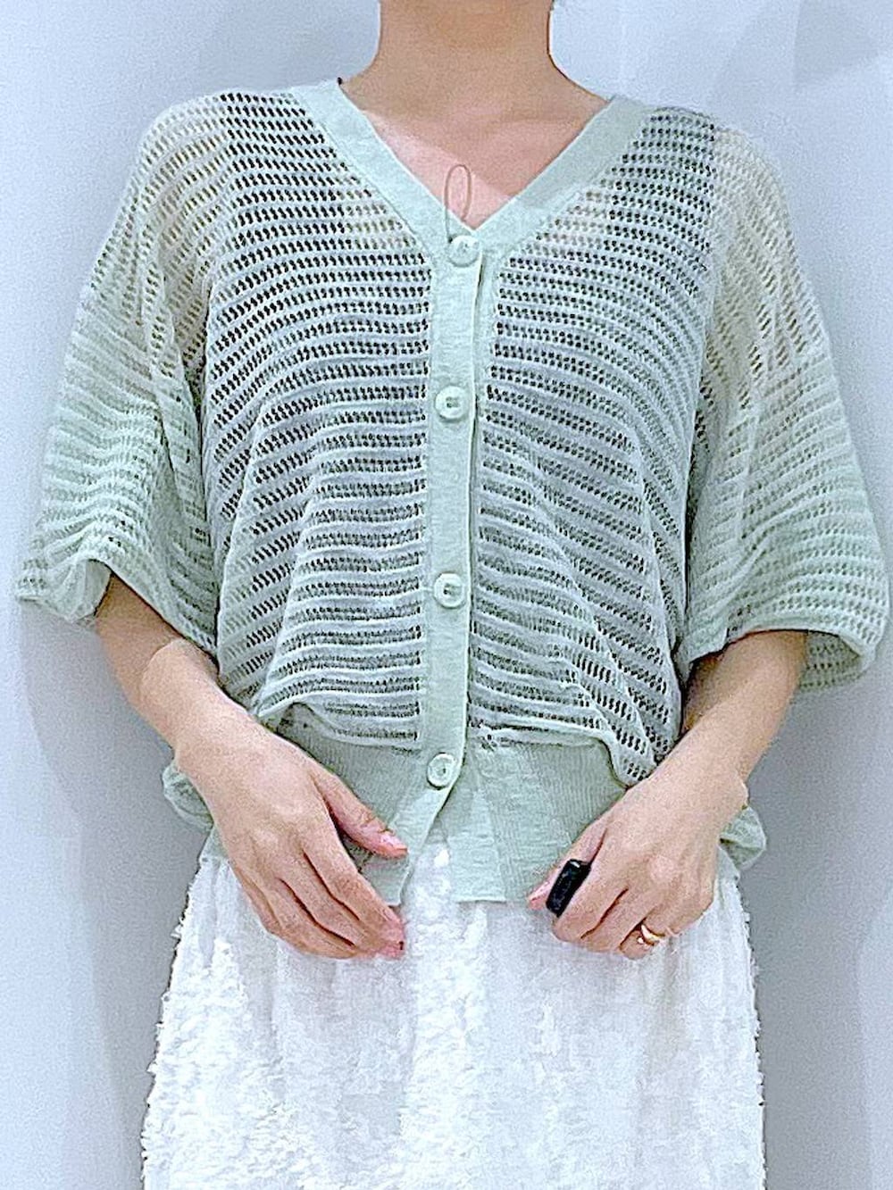 ブラック系のサンダル、ホワイト系のスカート、グリーン系のカーディガン/ボレロを着用したレディースの夏コーディネートの7枚目の写真