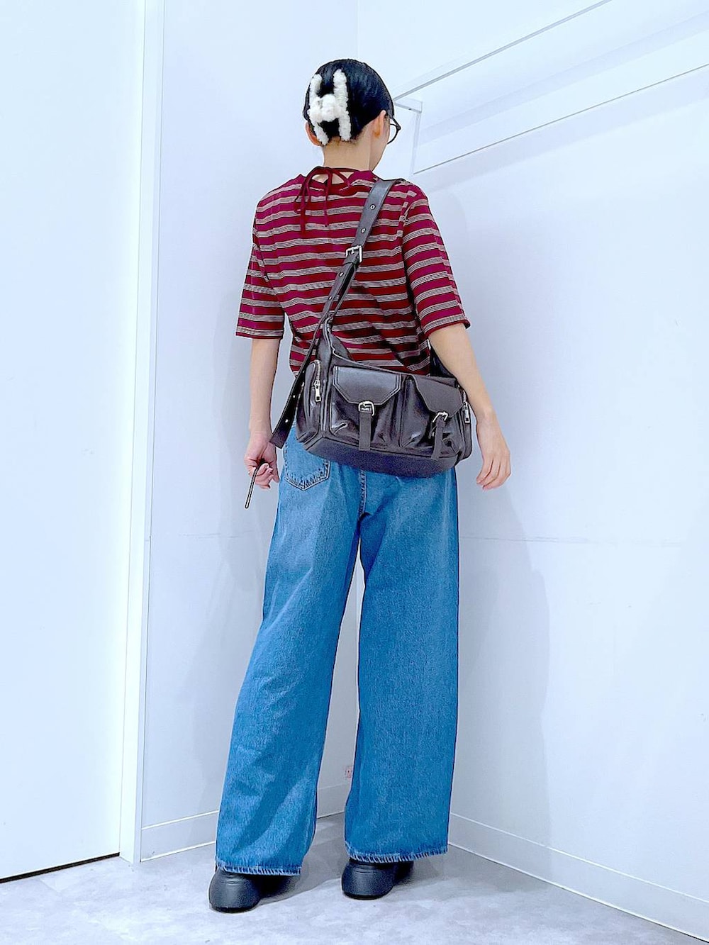 ブルー系のデニムパンツ、レッド系のTシャツ/カットソー、ブラック系のその他シューズを着用したレディースの秋コーディネートの5枚目の写真