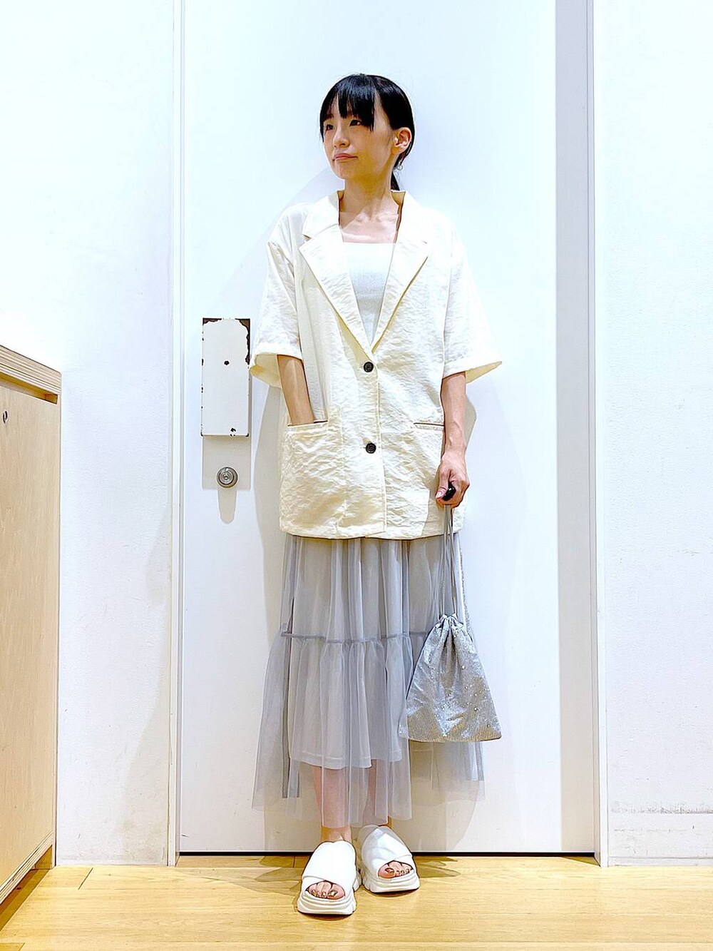 ホワイト系のサンダル、グレー系のショルダーバッグ、ホワイト系のニット/セーターを着用したレディースの夏コーディネートの2枚目の写真