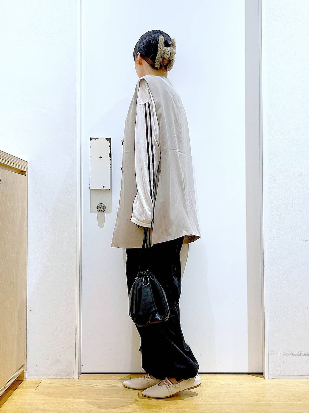 ブラック系のショルダーバッグ、ホワイト系のパンプス、ブラック系のその他パンツを着用したレディースの秋コーディネートの3枚目の写真