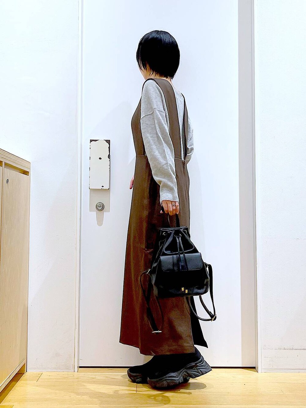 グレー系のニット/セーター、ブラック系のバックパック/リュック、ブラック系のブーツを着用したレディースの冬コーディネートの3枚目の写真