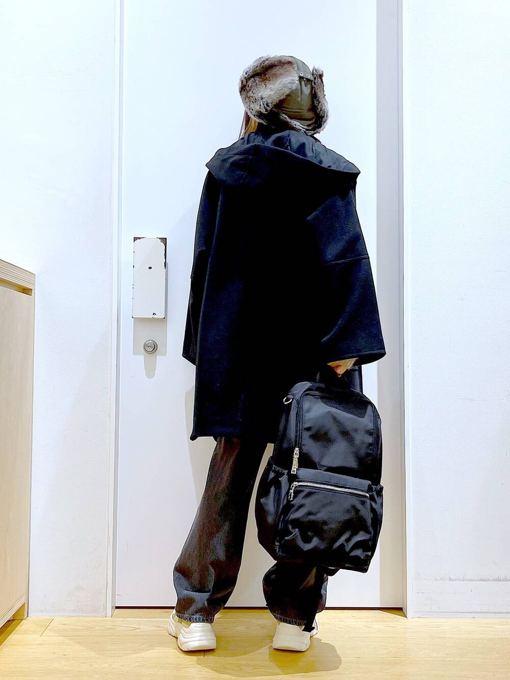 ブラック系のバックパック/リュック、ブラック系のその他アウター、ベージュ系のスニーカーを着用したレディースの冬コーディネートの5枚目の写真