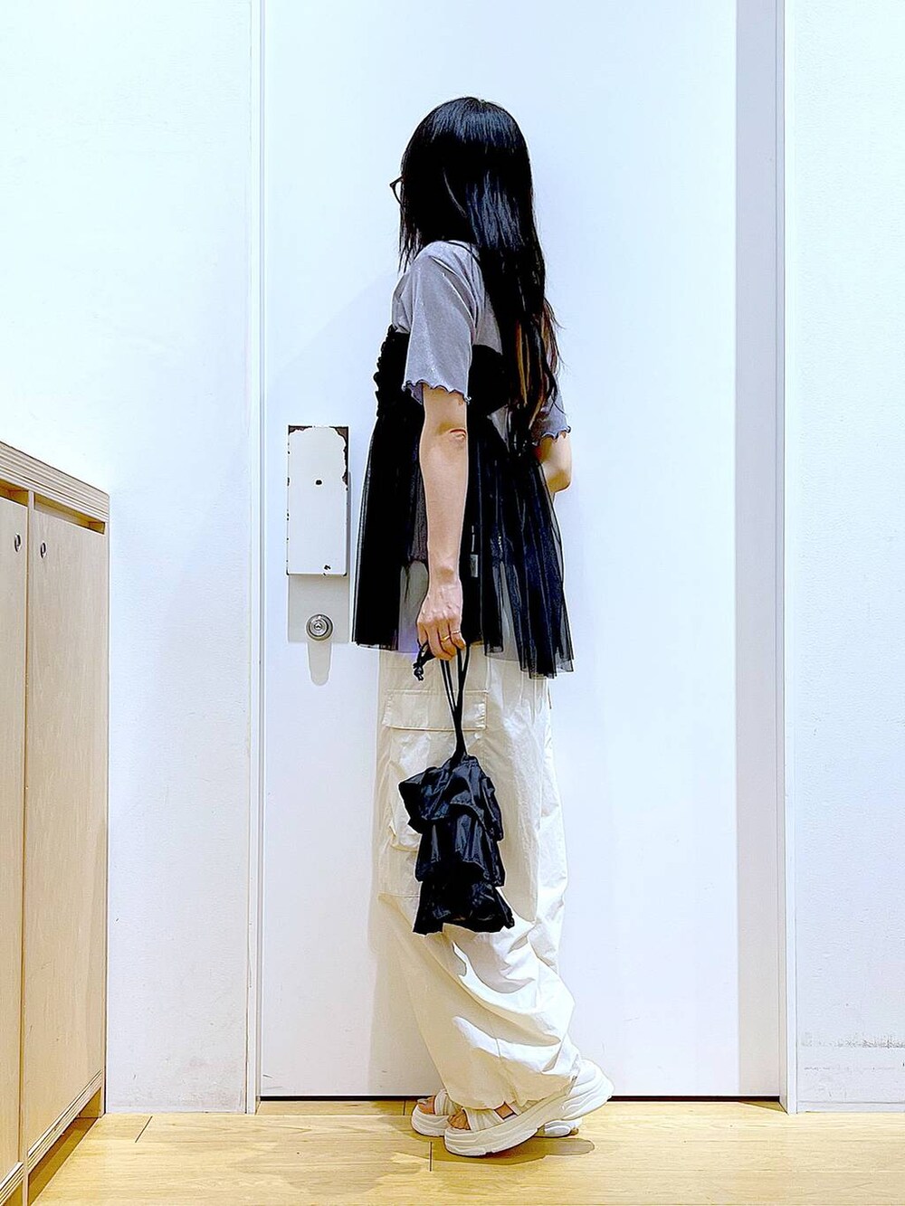 ブラック系のショルダーバッグ、ホワイト系のカーゴパンツ、ブラック系のキャミソールを着用したレディースの夏コーディネートの3枚目の写真