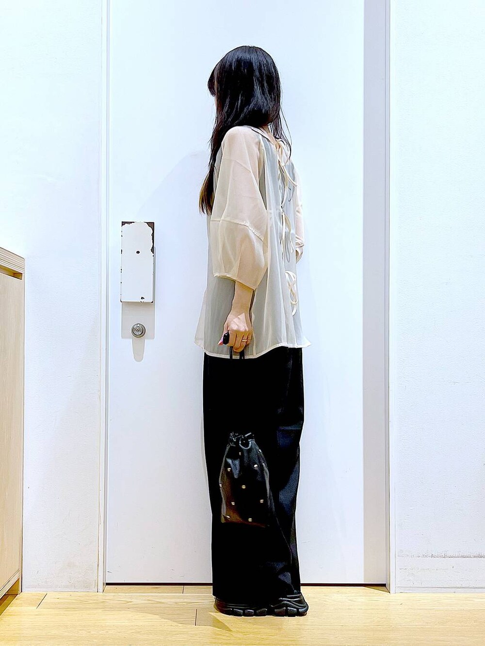 ブラック系のサンダル、ブラック系のニット/セーター、ブラック系のショルダーバッグを着用したレディースの夏コーディネートの3枚目の写真