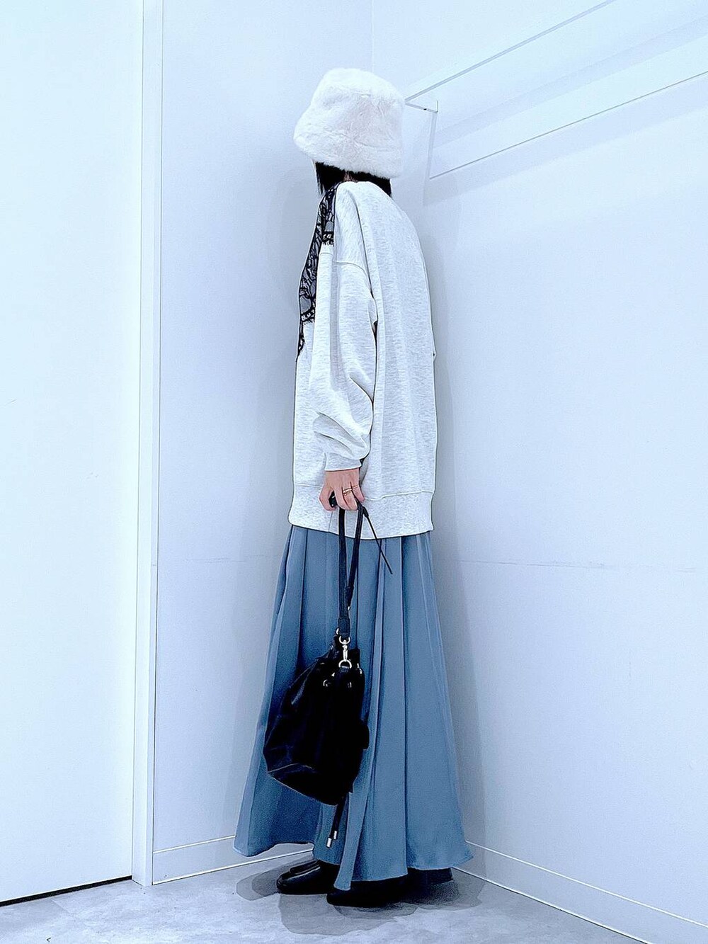 ブラック系のショルダーバッグ、ブラック系のブーツ、ベージュ系のスウェットを着用したレディースの冬コーディネートの3枚目の写真