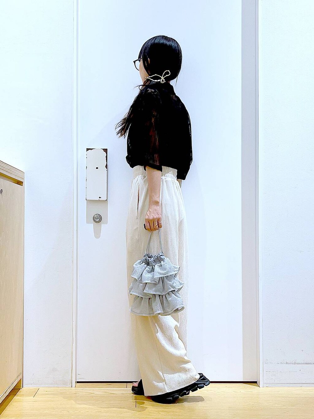 シルバー系のショルダーバッグ、ブラック系のサンダル、ブラック系のシャツ/ブラウスを着用したレディースの夏コーディネートの3枚目の写真