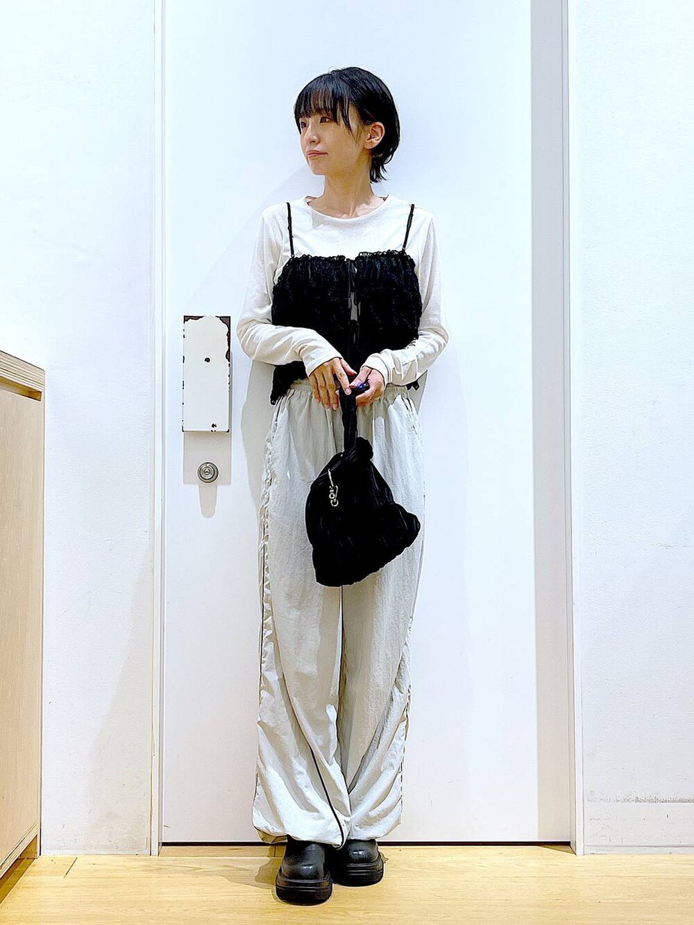 ブラック系のブーツ、ブラック系のショルダーバッグ、ホワイト系のTシャツ/カットソーを着用したレディースの秋コーディネートの2枚目の写真