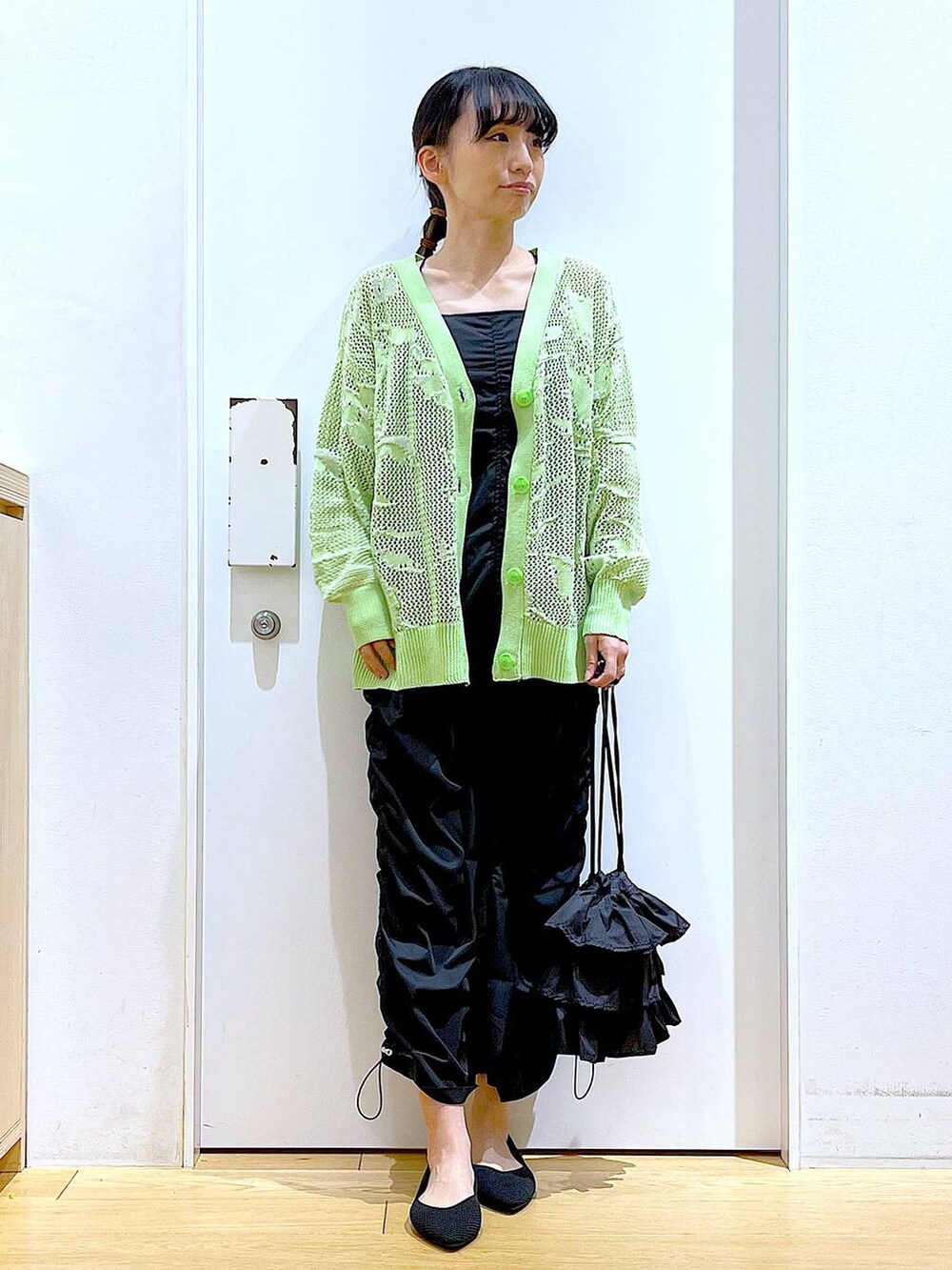 ブラック系のショルダーバッグ、ブラック系のパンプス、ブラック系のワンピースを着用したレディースの春コーディネートの2枚目の写真