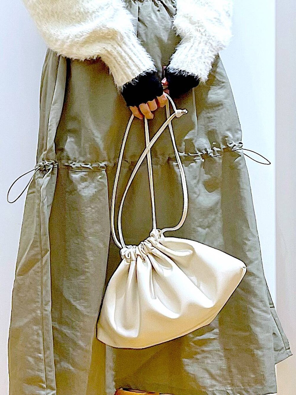 ベージュ系のショルダーバッグ、ベージュ系のブーツ、ベージュ系のニット/セーターを着用したレディースの冬コーディネートの9枚目の写真