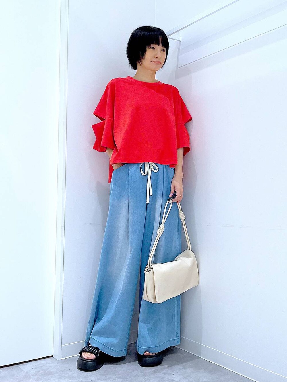 ブラック系のサンダル、レッド系のTシャツ/カットソー、ホワイト系のショルダーバッグを着用したレディースの夏コーディネートの2枚目の写真