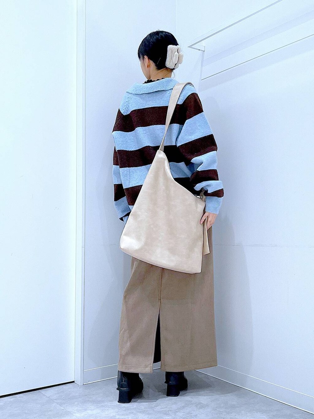 ブラック系のブーツ、ブラウン系のスカート、ブルー系のニット/セーターを着用したレディースの冬コーディネートの5枚目の写真