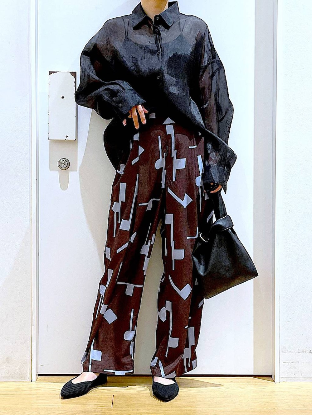 ブラック系のショルダーバッグ、ブラック系のパンプス、ブラウン系のその他パンツを着用したレディースの春コーディネートの6枚目の写真