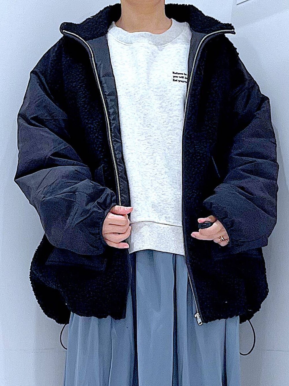 ブラック系のブルゾン、ブラック系のブーツ、ブルー系のスカートを着用したレディースの冬コーディネートの7枚目の写真