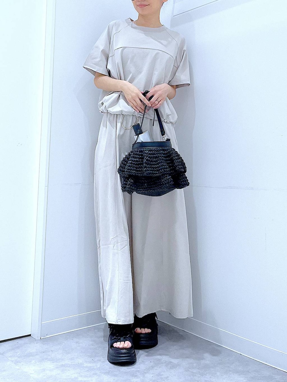 ブラック系のショルダーバッグ、ブラック系のサンダル、グレー系のTシャツ/カットソーを着用したレディースの夏コーディネートの6枚目の写真