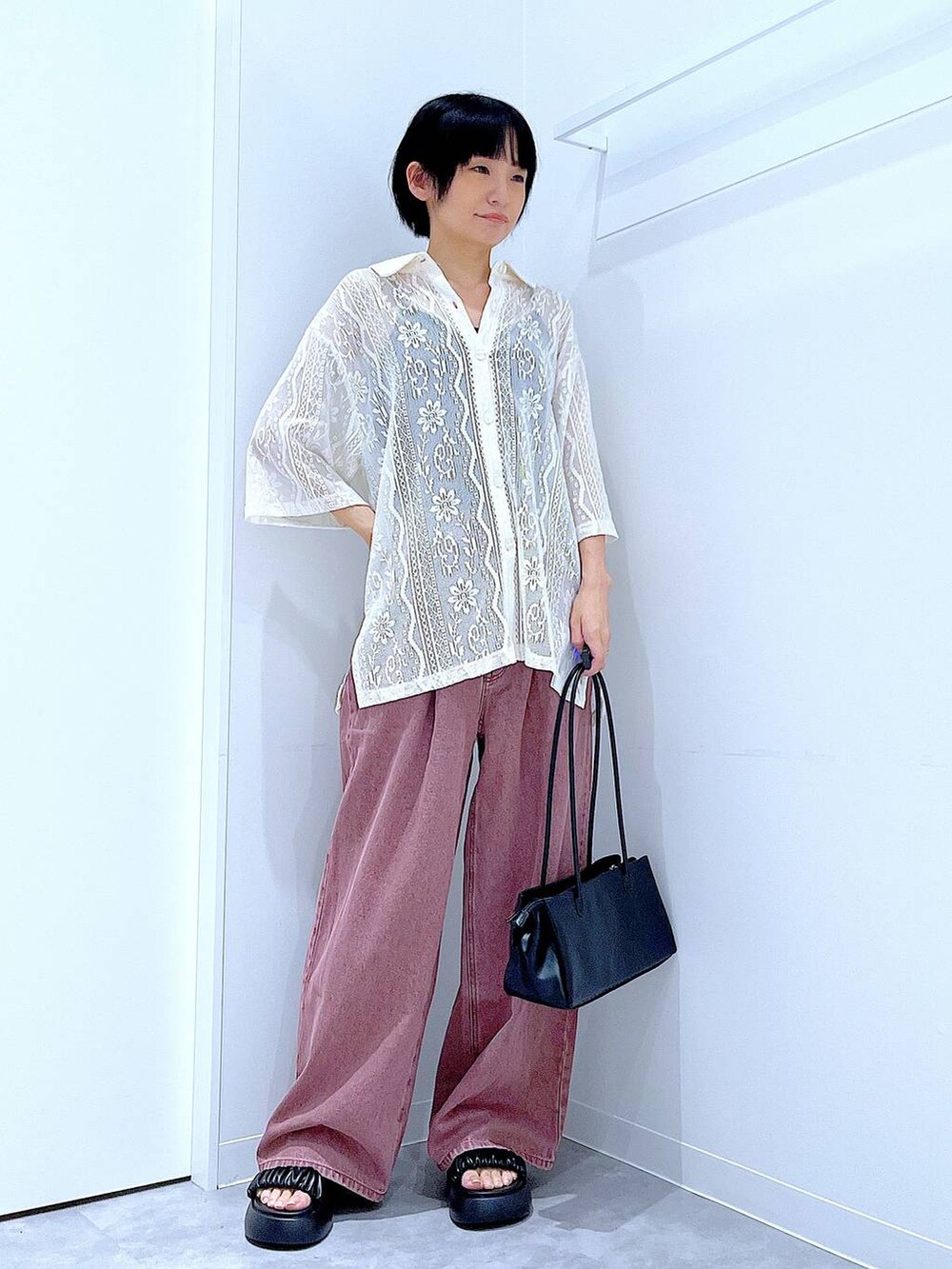 ブラック系のトートバッグ、ブラック系のサンダル、ホワイト系のシャツ/ブラウスを着用したレディースの夏コーディネートの2枚目の写真