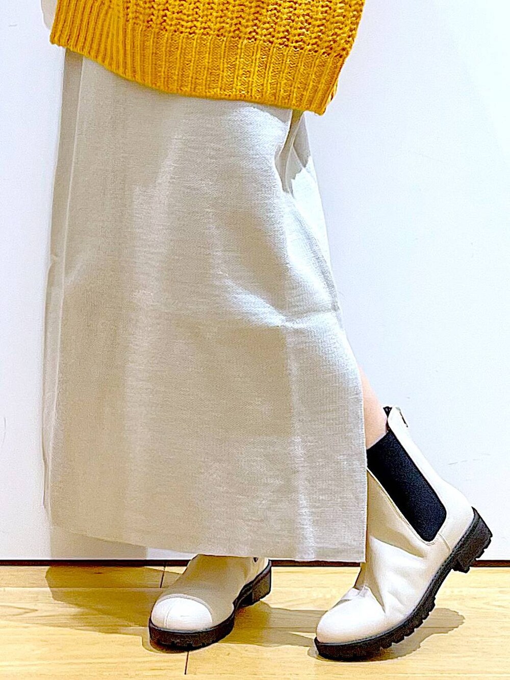 グレー系のスカート、ベージュ系のブーツ、ベージュ系のショルダーバッグを着用したレディースの冬コーディネートの8枚目の写真