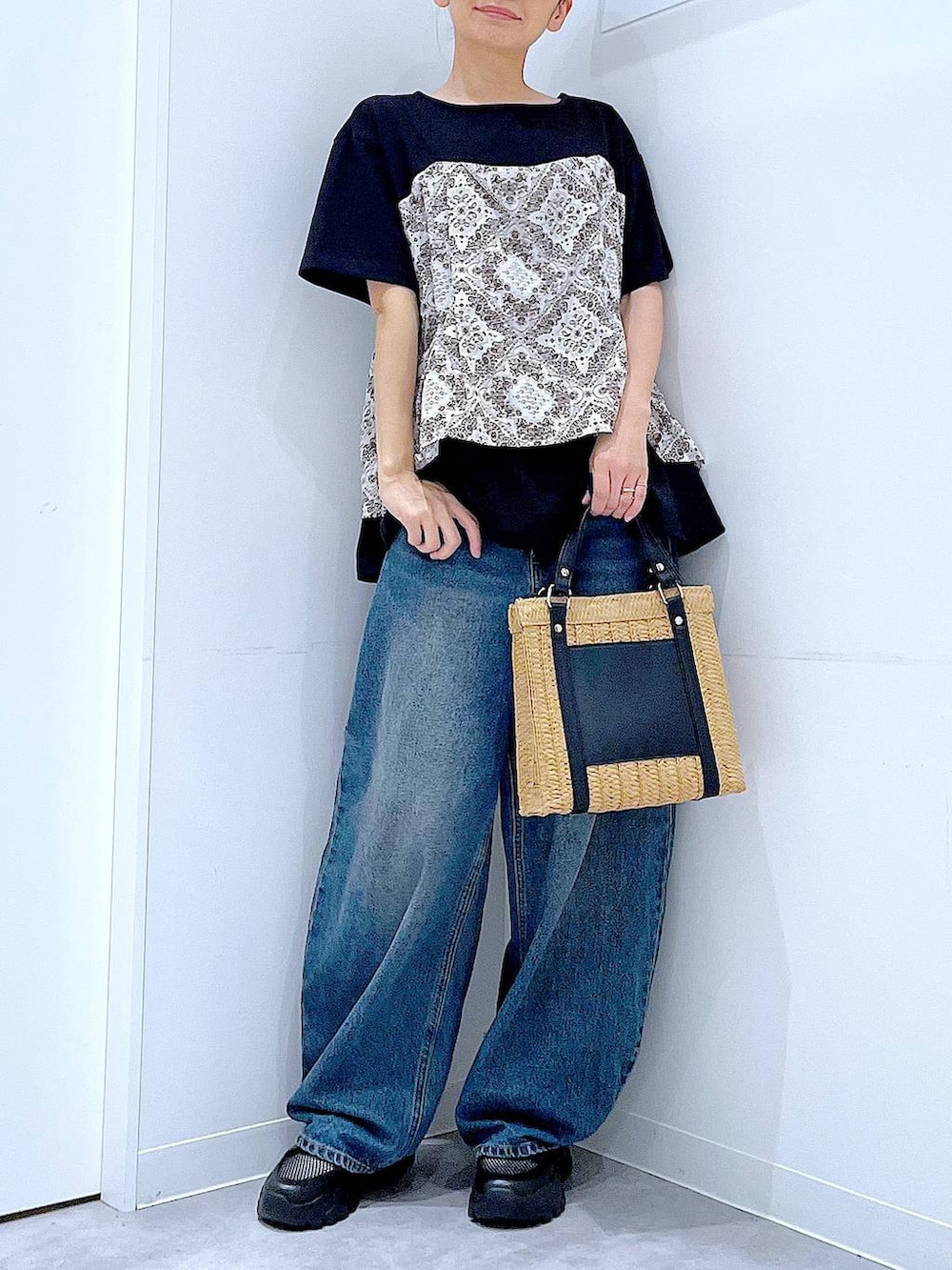 ブルー系のデニムパンツ、ブラック系のスニーカー、ブラック系のTシャツ/カットソーを着用したレディースの春コーディネートの6枚目の写真