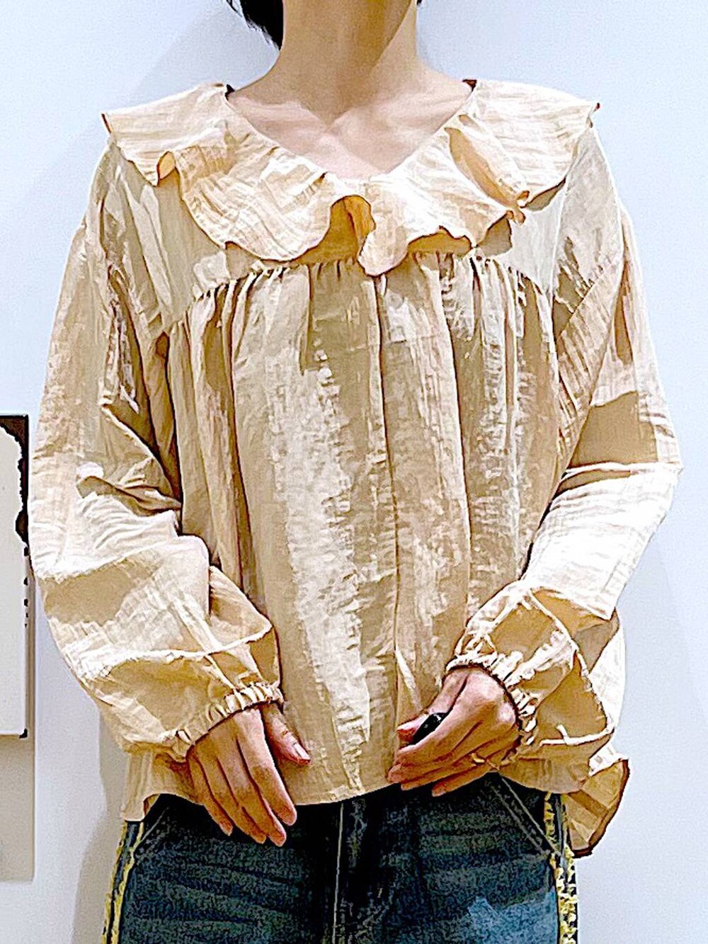 ホワイト系のボストンバッグ、ホワイト系のスニーカー、ブルー系のデニムパンツを着用したレディースの春コーディネートの7枚目の写真