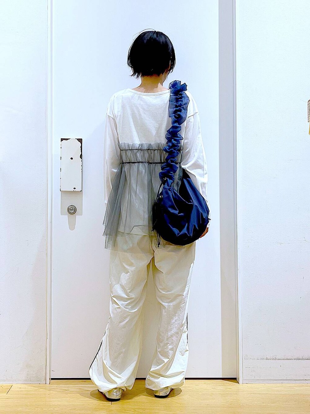 シルバー系のパンプス、ブルー系のショルダーバッグ、グレー系のTシャツ/カットソーを着用したレディースの秋コーディネートの5枚目の写真