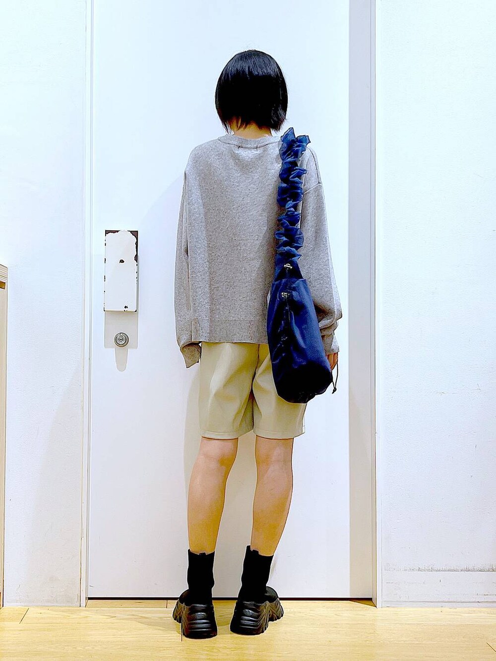 ブルー系のショルダーバッグ、ブラック系のブーツ、ベージュ系のその他パンツを着用したレディースの冬コーディネートの5枚目の写真