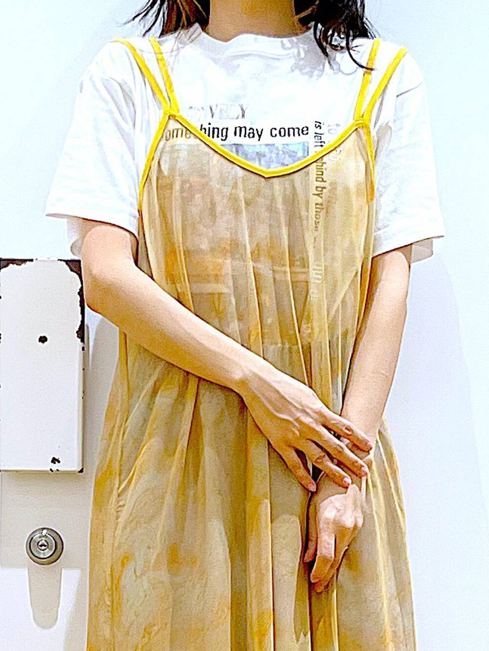 シルバー系のサンダル、オレンジ系のワンピース、ブラック系のショルダーバッグを着用したレディースの夏コーディネートの7枚目の写真