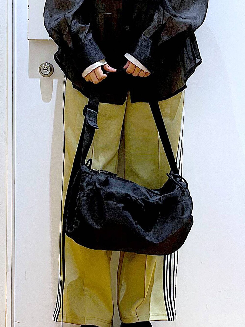 グリーン系のその他パンツ、ブラック系のスニーカー、ブラック系のショルダーバッグを着用したレディースの春コーディネートの9枚目の写真