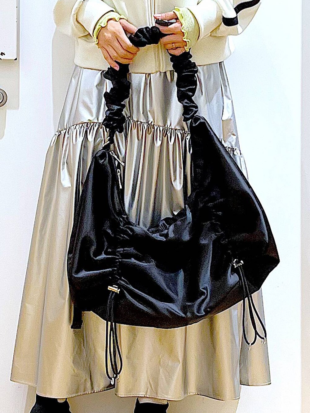 グリーン系のTシャツ/カットソー、ベージュ系のブルゾン、ブラック系のスニーカーを着用したレディースの春コーディネートの9枚目の写真