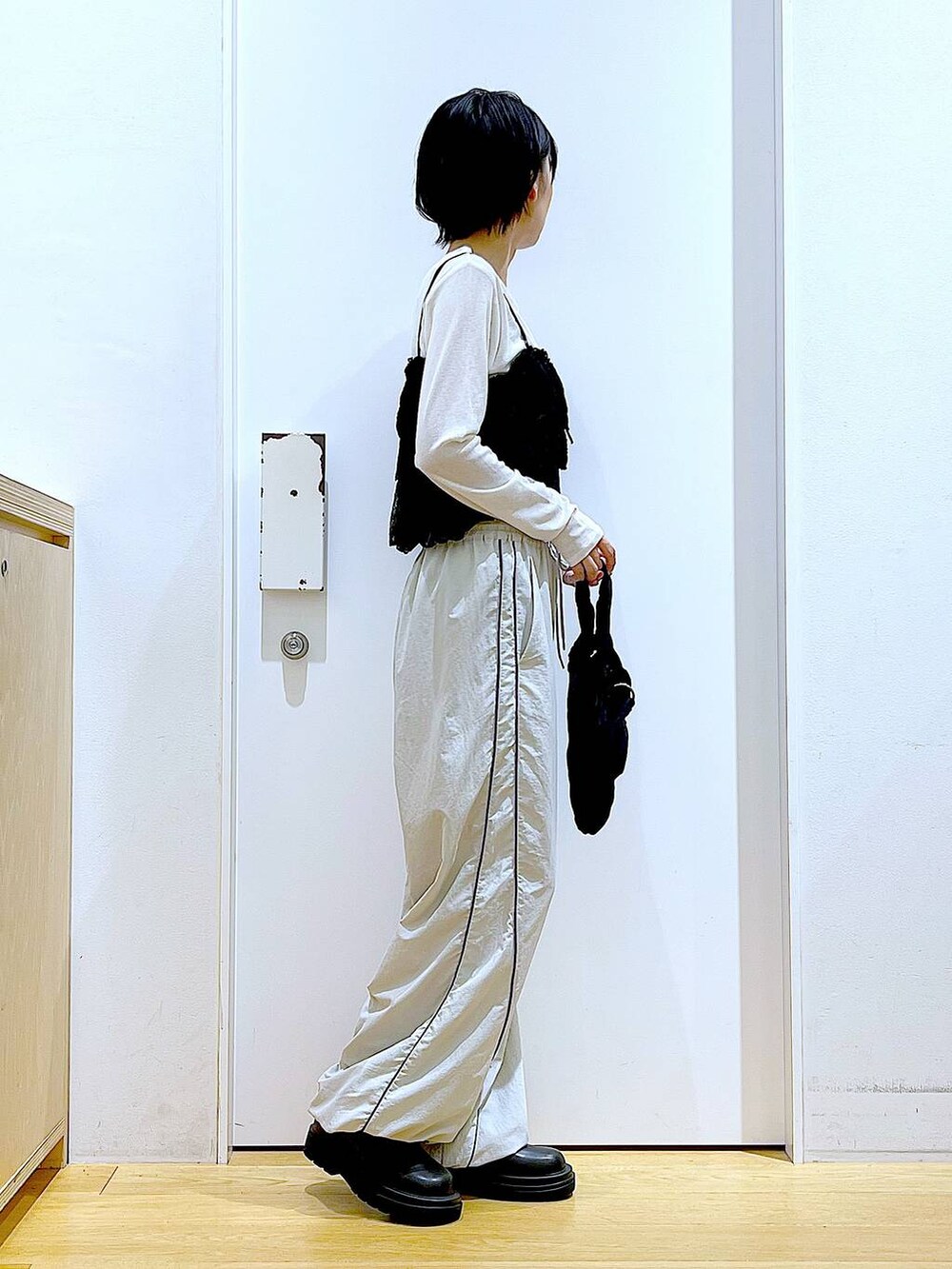 ブラック系のブーツ、ブラック系のショルダーバッグ、ホワイト系のTシャツ/カットソーを着用したレディースの秋コーディネートの4枚目の写真