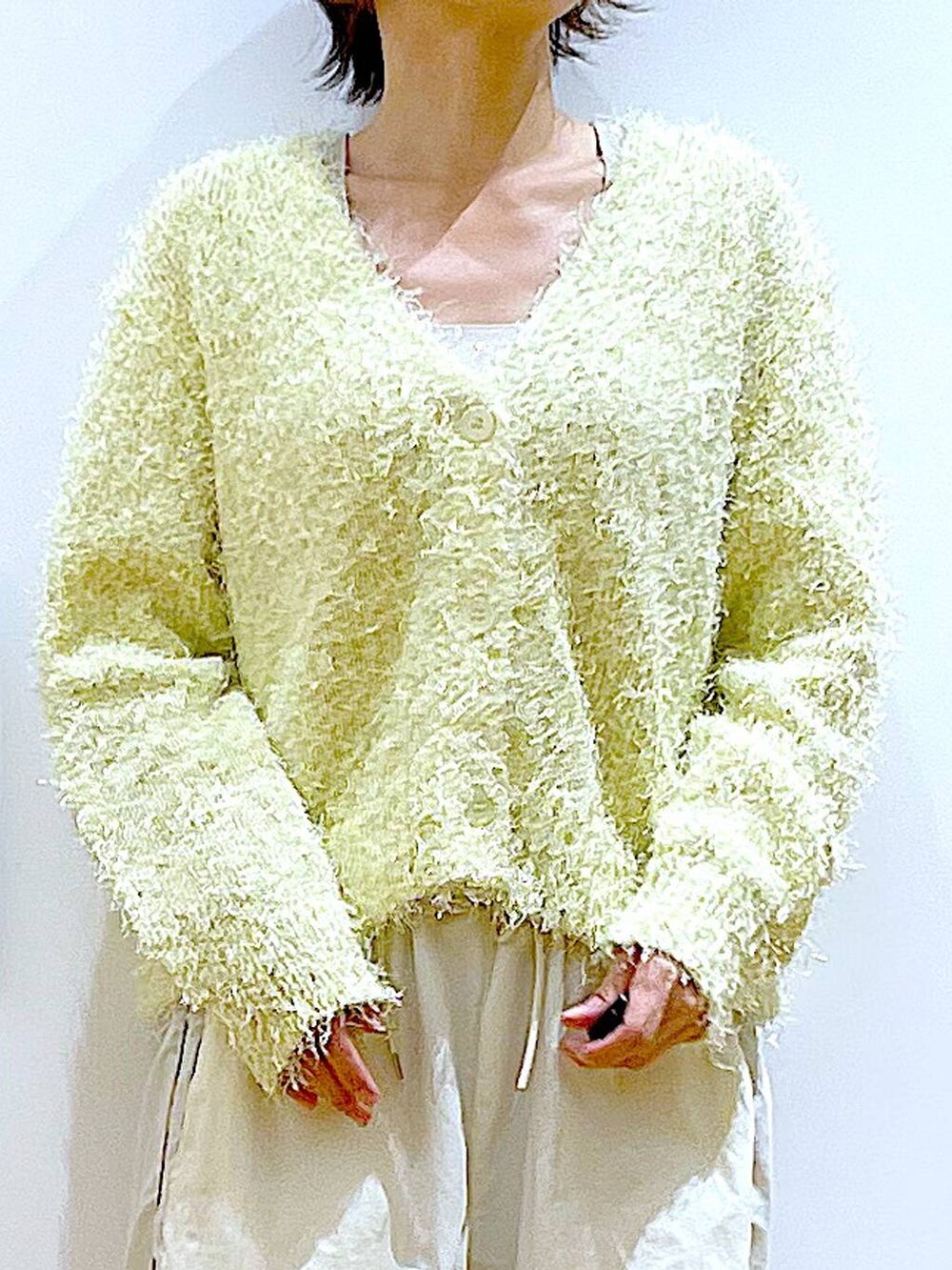 ベージュ系のショルダーバッグ、ホワイト系のスニーカー、イエロー系のカーディガン/ボレロを着用したレディースの秋コーディネートの7枚目の写真