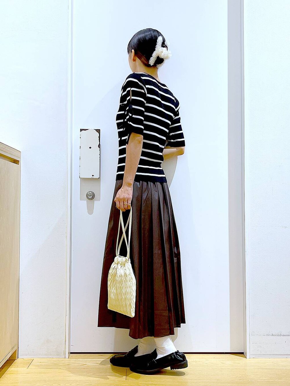 ホワイト系のショルダーバッグ、ブラック系のローファー、ブラック系のニット/セーターを着用したレディースの秋コーディネートの3枚目の写真