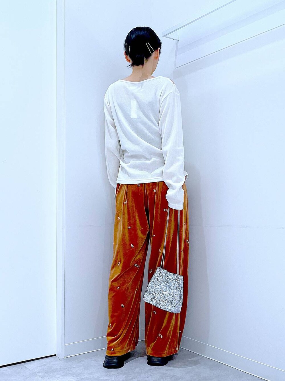 シルバー系のショルダーバッグ、ブラック系のローファー、ベージュ系のTシャツ/カットソーを着用したレディースの秋コーディネートの5枚目の写真