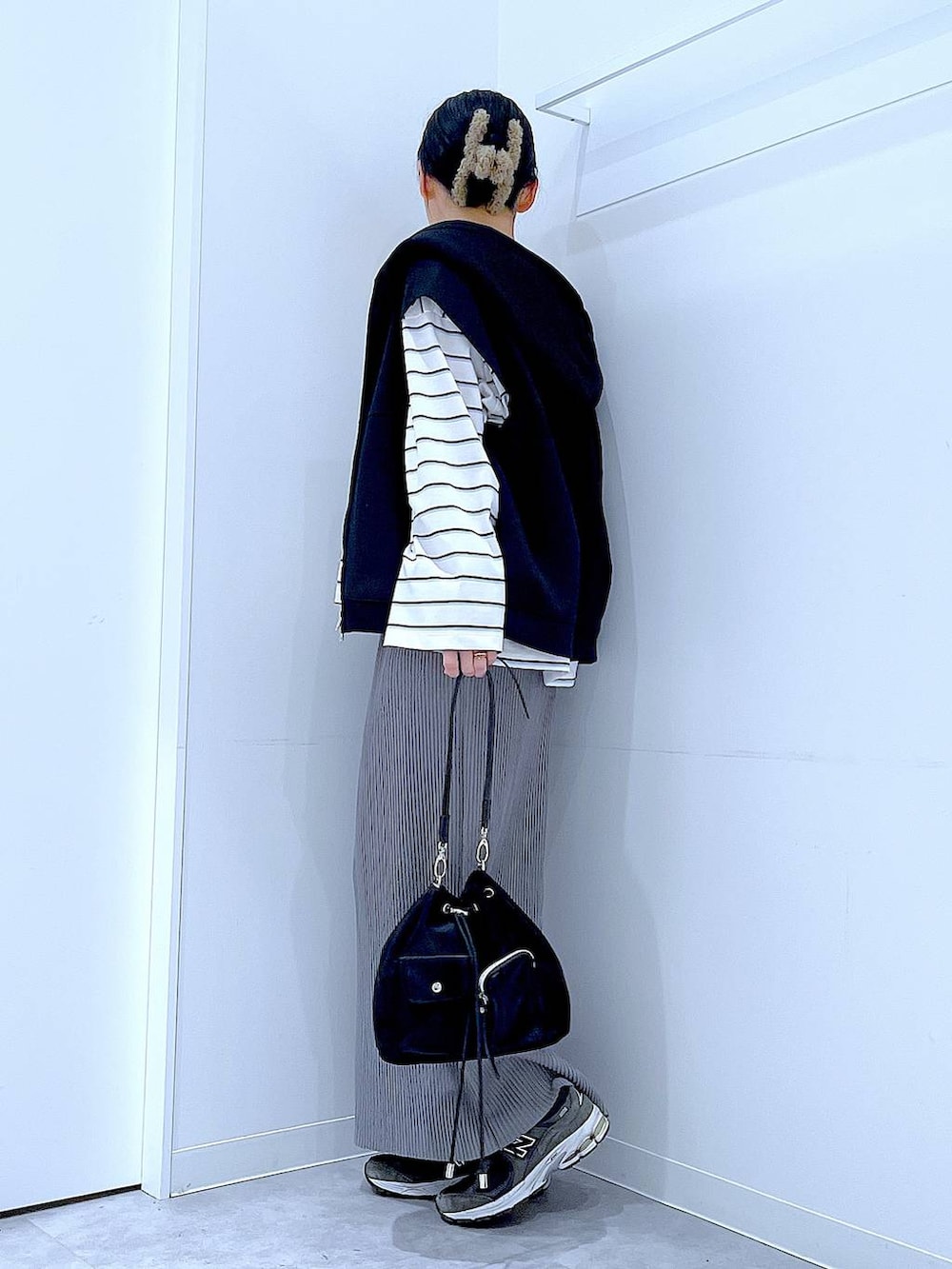 ブラック系のショルダーバッグ、ホワイト系のTシャツ/カットソー、グレー系のスカートを着用したレディースの春コーディネートの3枚目の写真