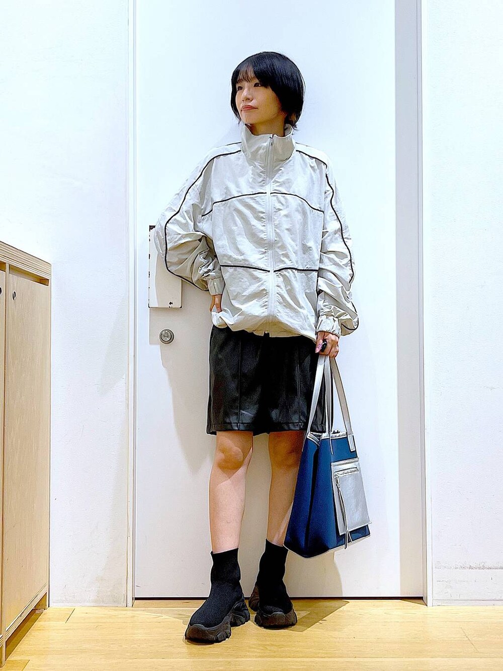 ブラック系のブーツ、ブルー系のトートバッグ、グレー系のブルゾンを着用したレディースの冬コーディネートの2枚目の写真