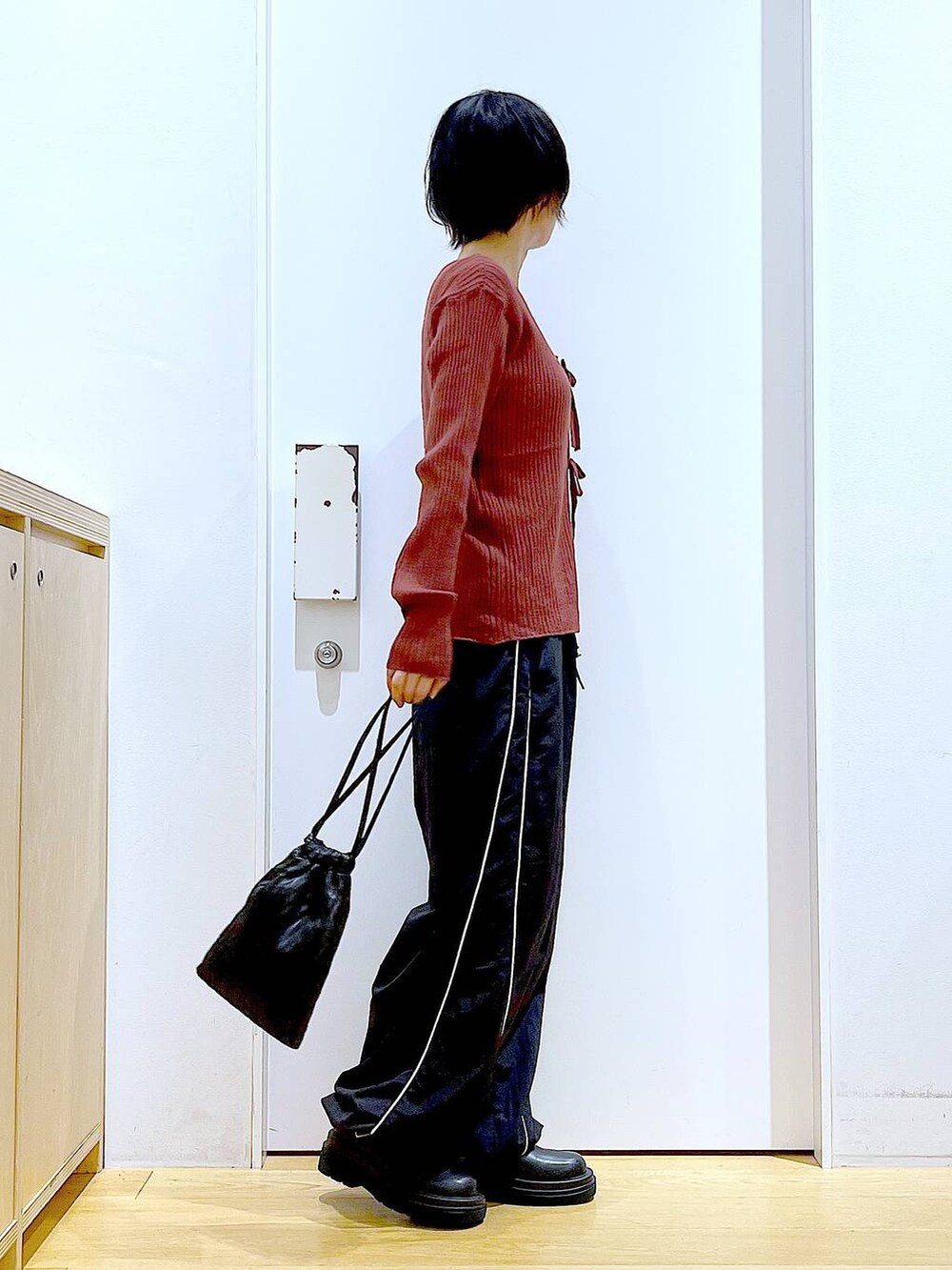 ブラック系のショルダーバッグ、ブラック系のブーツ、ブラウン系のカーディガン/ボレロを着用したレディースの秋コーディネートの4枚目の写真