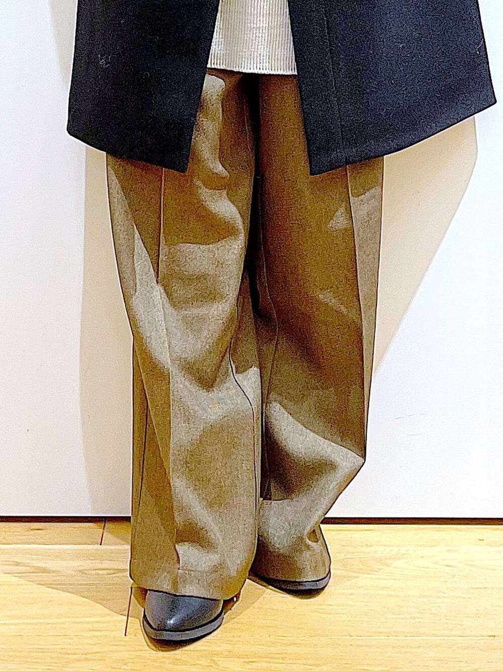 ブラック系のノーカラーコート、グレー系のショルダーバッグ、グレー系のニット/セーターを着用したレディースの冬コーディネートの6枚目の写真