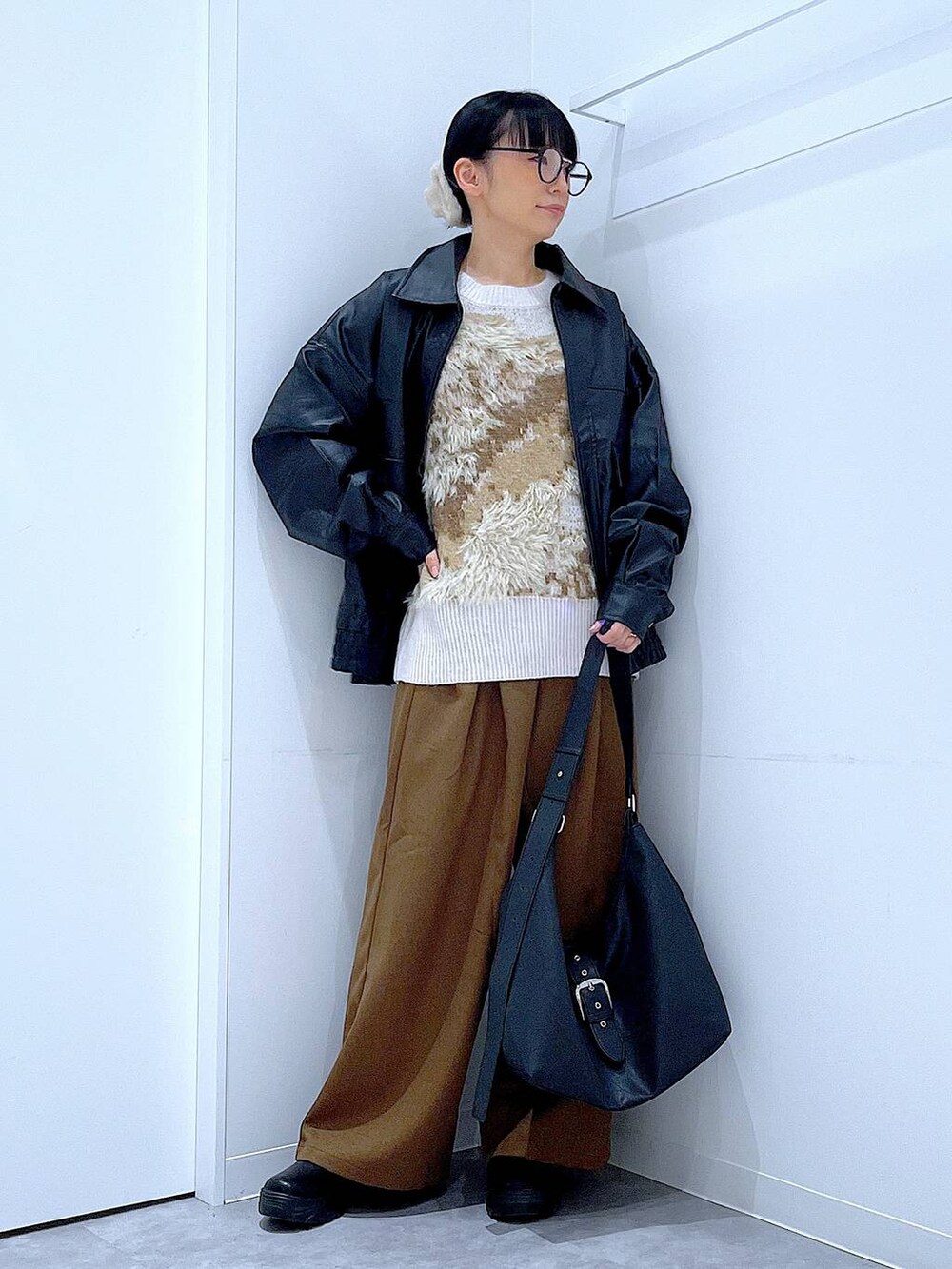 ブラック系のブルゾン、ブラック系のブーツ、ベージュ系のニット/セーターを着用したレディースの秋コーディネートの2枚目の写真