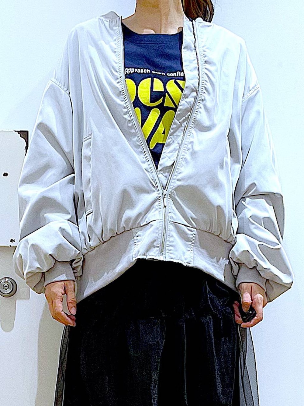 シルバー系のショルダーバッグ、グレー系のMA-1、ベージュ系のブーツを着用したレディースの春コーディネートの7枚目の写真