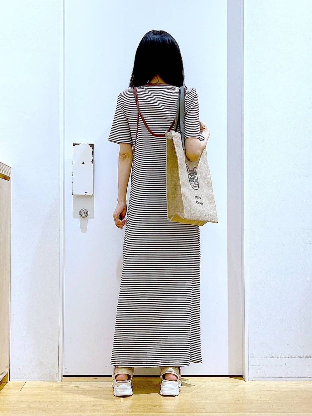 ベージュ系のサンダル、グレー系のトートバッグ、ベージュ系のワンピースを着用したレディースの夏コーディネートの5枚目の写真