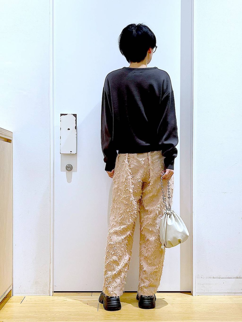 ベージュ系のショルダーバッグ、ブラック系のブーツ、グレー系のニット/セーターを着用したレディースの春コーディネートの5枚目の写真