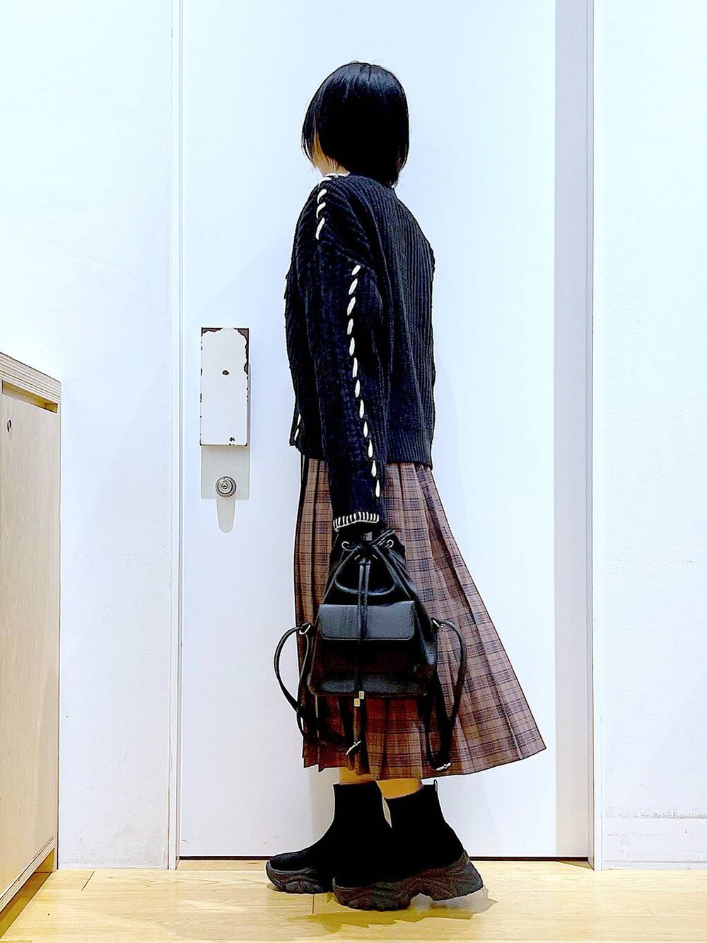 ブラック系のニット/セーター、ブラック系のバックパック/リュック、ブラック系のブーツを着用したレディースの冬コーディネートの3枚目の写真