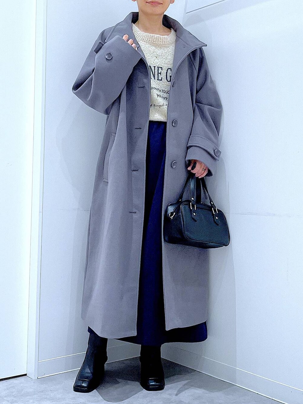 グレー系のその他アウター、ホワイト系のニット/セーター、ブルー系のスカートを着用したレディースの秋コーディネートの6枚目の写真