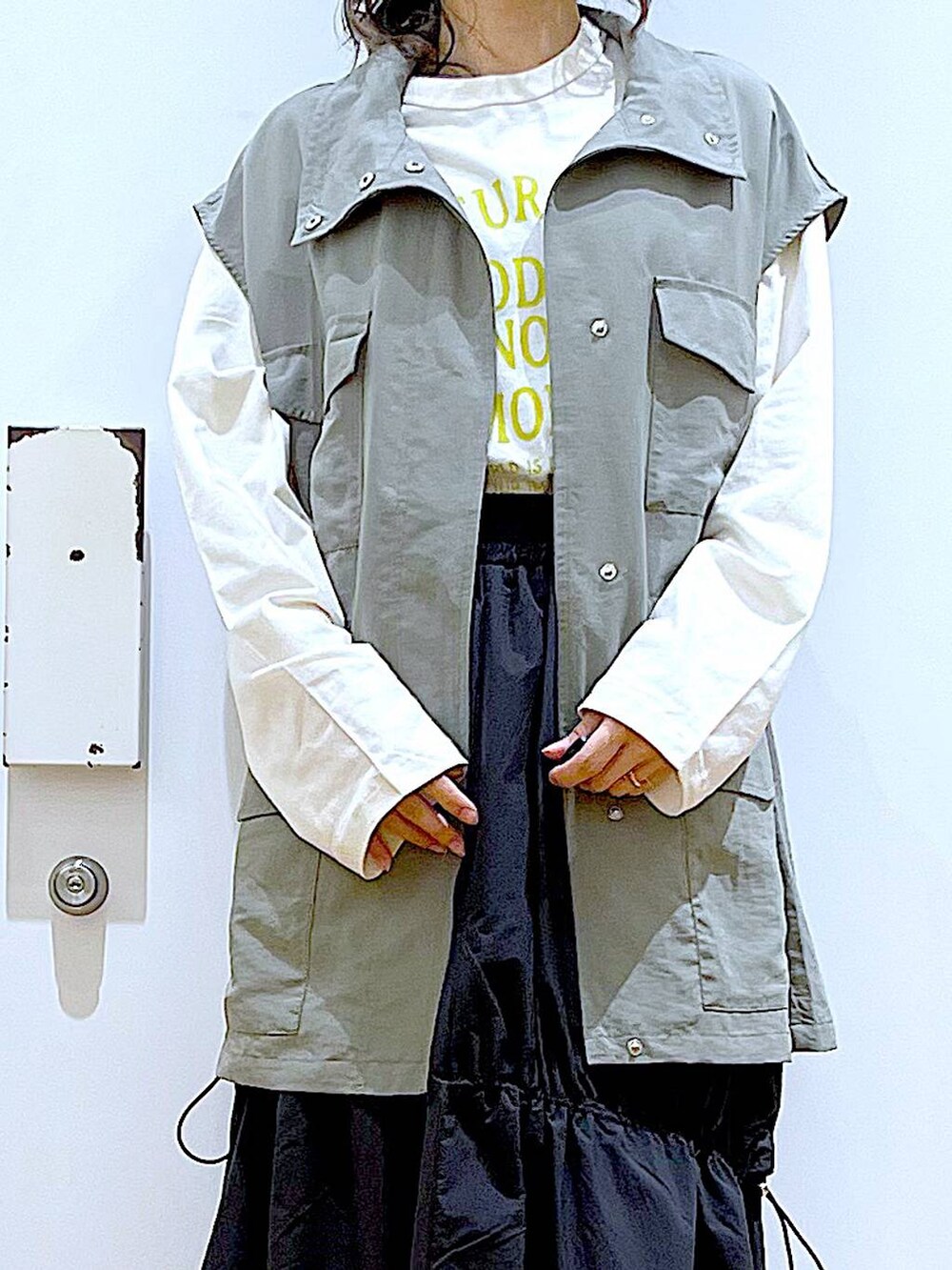 ブラック系のショルダーバッグ、ブラック系のスニーカー、ブラック系のスカートを着用したレディースの春コーディネートの7枚目の写真