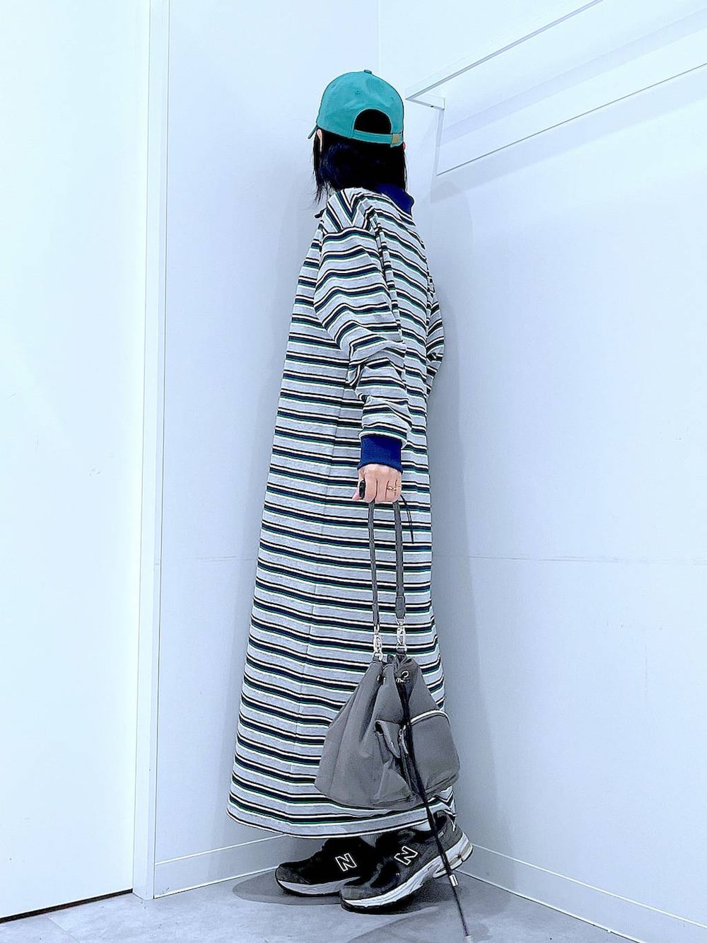 グリーン系のキャップを着用したレディースの春コーディネートの3枚目の写真